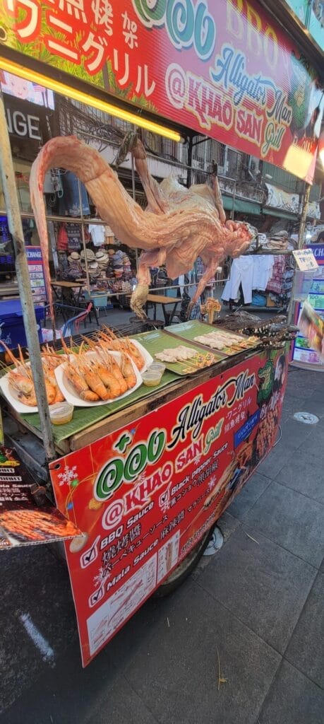 The Alligator Man Of Bangkok Displays His Skinned Alligator to Hungry Patrons