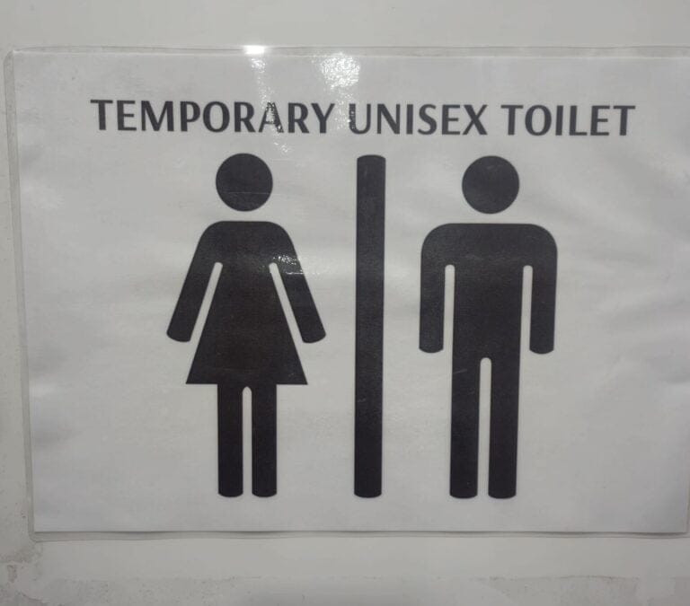 Sign On Toilet Door Notifying Users Its a Unisex Facility