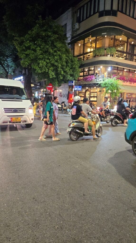 Pedestrian Weave Through A Busy Intersection In Hanoi